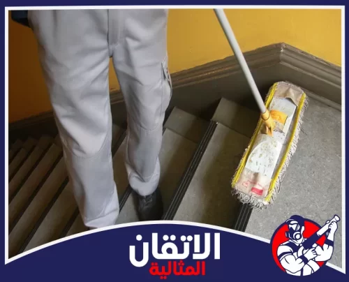 تنظيف الأرضيات والسيراميك في المدخل بالقطيف 0567008659 الأتقان المثالية عامل يقوم بغسيل أرضيات وسيراميك مداخل العمائر بالقطيف باستخدام ممسحة كبيرة لضمان نظافة الأسطح وكفاءة الممرات.