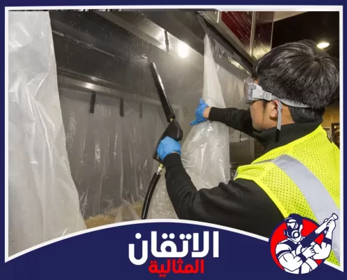 تنظيف مداخن المطابخ بالقطيف 0567008659 الأتقان المثالية فني يرتدي واقيات وقفازات ينظف شفاط مطبخ في مطعم بالقطيف باستخدام جهاز بخار لضمان إزالة الدهون والأوساخ بشكل آمن وفعال.