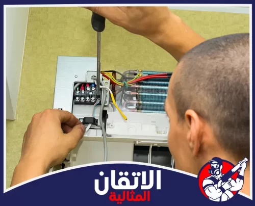 تعبئة فريون المكيفات بالدمام 0567008659 اتقان المثالية فني يقوم بفحص وتوصيل أسلاك المكيف الداخلي أثناء تعبئة غاز الفريون في الدمام لضمان تشغيل آمن وكفاءة تبريد عالية.