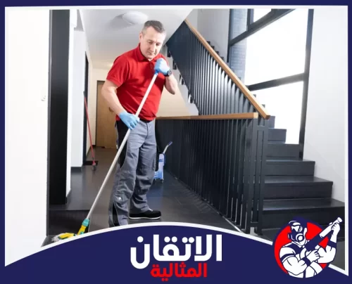 غسيل أرضيات مداخل العمائر بالجبيل 0567008659 شركة أتقان المثالية عامل تنظيف يرتدي قفازات ويقوم بمسح وتطهير أرضية الممر بجانب السلالم