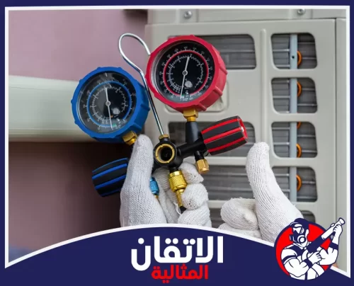 شحن فريون تكييف مركزي بالدمام 0567008659 اتقان المثالية فني يحمل جهاز قياس ضغط غاز الفريون أمام وحدة مكيف مركزي في الدمام لفحص الضغط وضمان شحن آمن وكفاءة تبريد عالية.