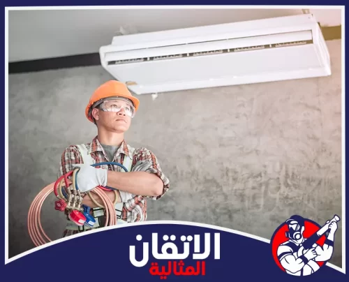 تعبئة فريون مكيف سبليت بالدمام 0567008659 اتقان المثالية فني يرتدي خوذة ونظارات واقية يحمل أدوات تعبئة غاز الفريون أمام وحدة مكيف سبليت في الدمام لضمان شحن آمن وكفاءة تبريد عالية.