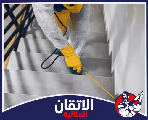 مكافحة الفئران والقوارض بالقطيف 0567008659 الأتقان المثالية فني يرتدي بدلة وقفازات واقية يرش مبيدات على السلالم الداخلية لمنع الحشرات والآفات في المباني بالقطيف بشكل آمن وفعال.