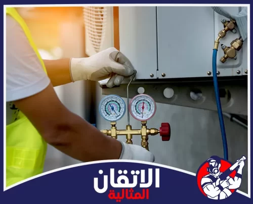 شحن فريون مكيف شباك بالجبيل 0567008659 أتقان المثالية فني صيانة مكيفات يستخدم عدادات قياس ضغط الفريون لفحص وشحن مكيف، مع ظهور شعار اتقان المثالية أسفل التصميم.