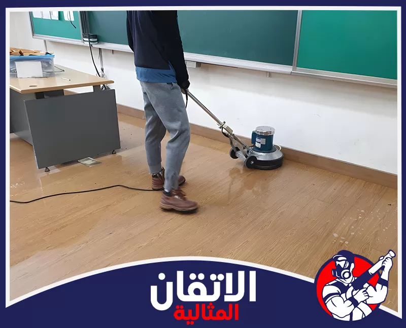 تنظيف وتعقيم الفصول الدراسية في الدمام 0567008659 شركة أتقان المثالية عامل ينظف أرضية الفصل الدراسي بآلة الجلي الكبيرة لإعادة البريق للمكان قبل بدء الدراسة.