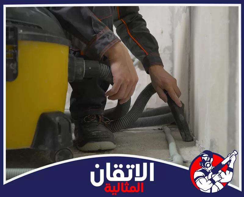 إزالة مخلفات البناء والأسمنت في الخبر 0567008659 شركة أتقان المثالية عامل يستخدم مكنسة كهربائية صناعية صفراء قوية لإزالة الأتربة من زوايا الغرفة
