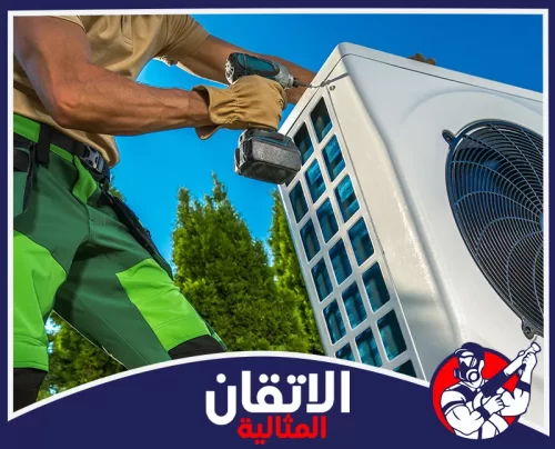 صيانة مكيفات سبليت بالدمام 0567008659 أتقان المثالية فني يقوم بصيانة وحدة مكيف خارجية في الدمام باستخدام مفك كهربائي لضمان تثبيت الأجزاء وتحسين أداء التبريد.